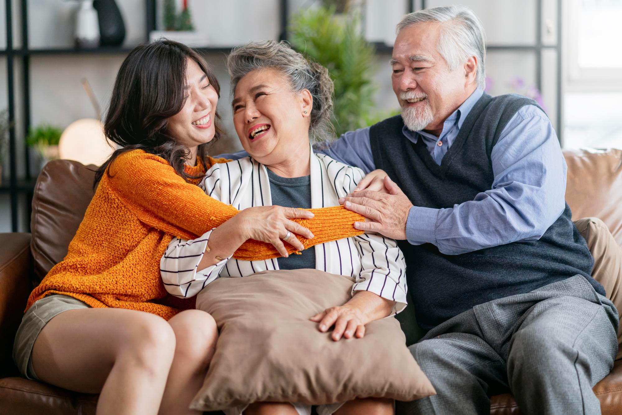 happiness-asian-family-candid-daughter-hug-grandparent-mother-farther-senior-elder-cozy-relax-sofa-couch-surprise-visiting-living-room-hometogether-hug-cheerful-asian-family-home